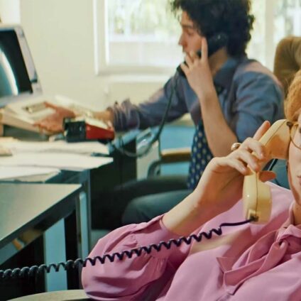 Kinderen in een callcenter, gekleed in zakelijke outfits, voeren telefoongesprekken alsof ze scheidingszaken regelen.