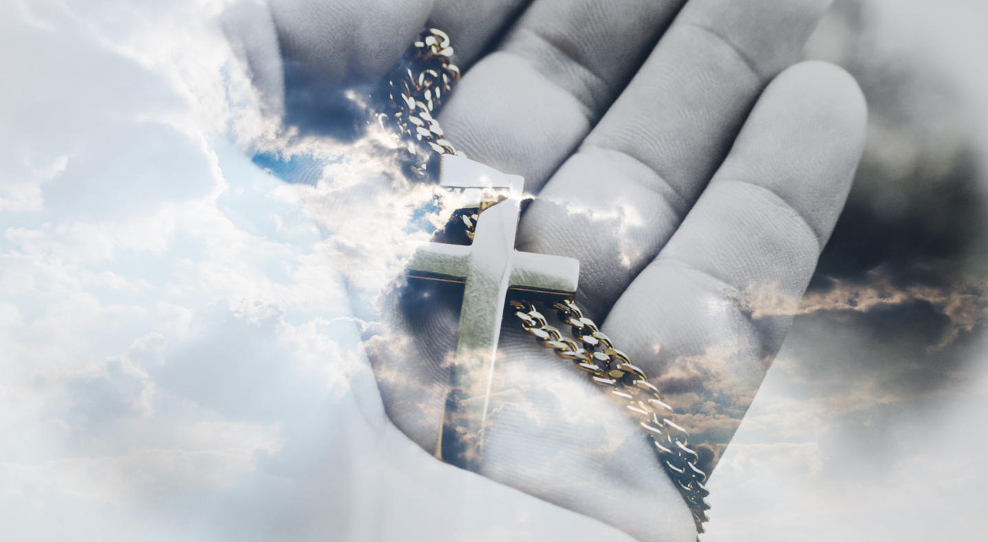 Een hand houdt een kruisje aan een ketting vast tegen een wolkenlucht, symbool voor geloof en morele overwegingen. Mag je scheiden binnen het christendom? Een innerlijke strijd tussen traditie en persoonlijke keuze."