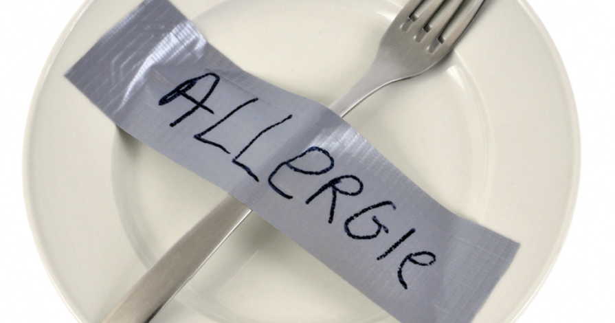 Een vork vastgeplakt met tape op een bord, met het woord 'allergie' erop geschreven. Symbolisch voor wat je op je bord krijgt bij een echtscheiding.