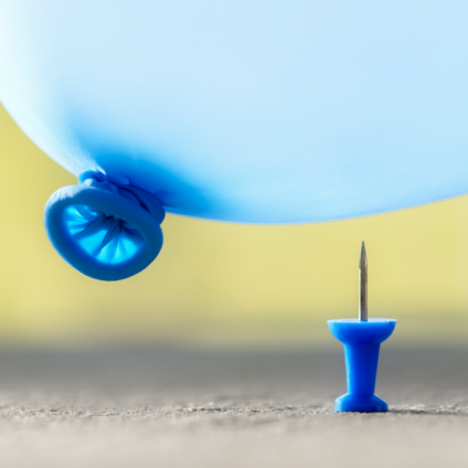 Blauwe ballon hangt boven een punaise; Kwetsbaarheid tijdens de scheiding.