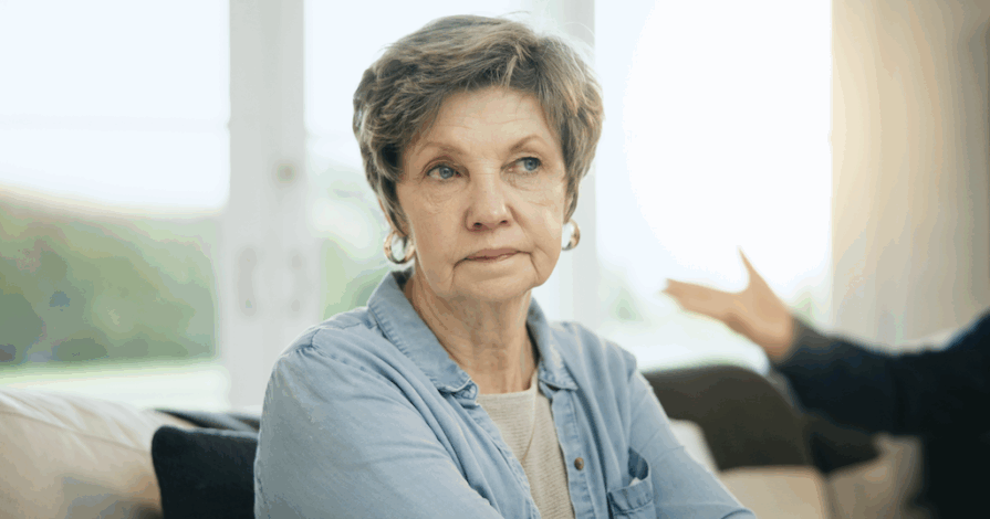 vrouw op leeftijd die twijfelt over haar relatie. man die haar niet begrijpt op de achtergrond