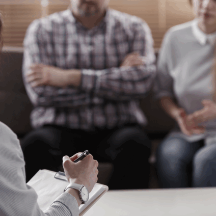 mediator scheiden aan het werk bij een familieconflict. Je ziet de mediator op de rug en partijen geanodiseerd