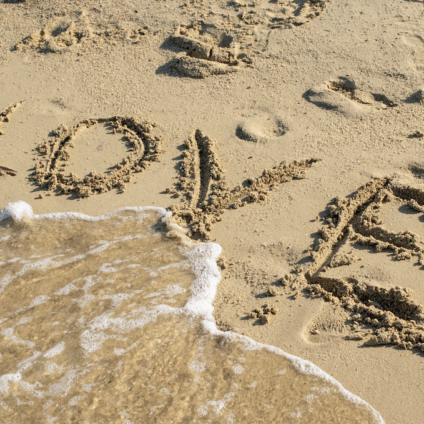Als de liefde verdwijnt, de zee spoelt de letters love weg in het zand