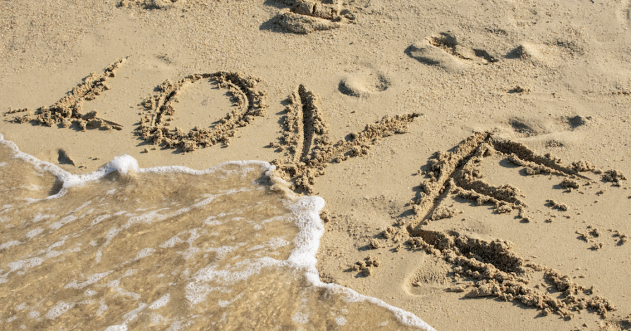 Als de liefde verdwijnt, de zee spoelt de letters love weg in het zand