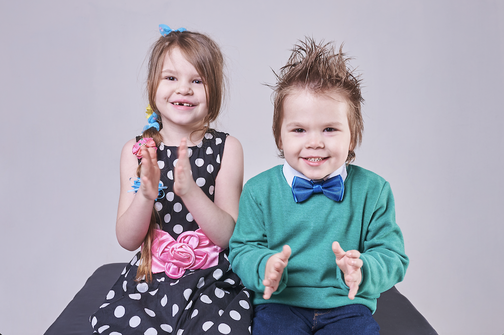Kinderen die lachen en klappen nadat ouders open met hen hebben gesproken over een scheiding.