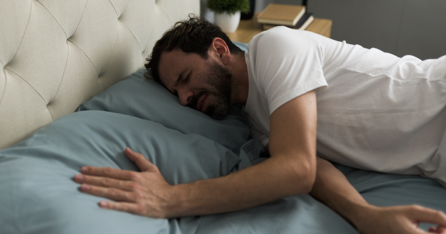 Man ligt alleen in bed en voelt angst om alleen te zijn na een scheiding