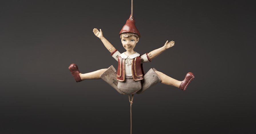 pinokkio pop die aan touwtjes hangt symbool voor kind dat tussen ouders staat bij scheiding