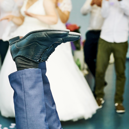 Man struikelt tijdens bruiloft terwijl bruid op de achtergrond staat, symbool voor relatiebreuk en scheiding