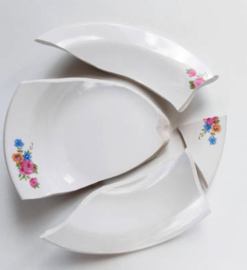 Bord met bloemen in stukken als symbool voor relatiebreuk in Gieten