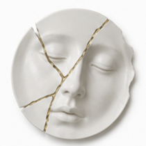 Bord met sculptuur van vrouwengezicht en gouden kintsugi scheuren bij scheiding in Nieuw-Beijerland