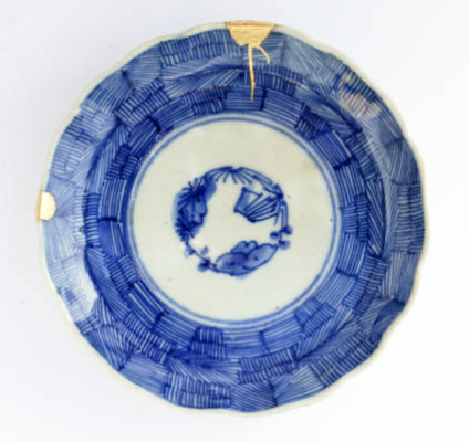 Antiek blauw bord met gouden herstel bij scheiden in Okkenbroek