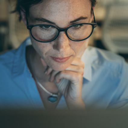 Vrouw werkt geconcentreerd achter laptop terwijl het artikel gaat over werk, zelfzorg, relaties en jezelf verliezen in verantwoordelijkheid.