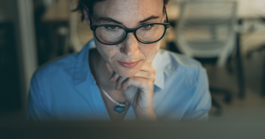 Vrouw werkt geconcentreerd achter laptop terwijl het artikel gaat over werk, zelfzorg, relaties en jezelf verliezen in verantwoordelijkheid.